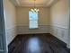 Formal dining room with elegant wainscoting, dark hardwood floors, and a decorative chandelier at 185 Bourne Dr, Franklinton, NC 27525