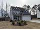 Well-manicured front yard with a two-story home featuring gray siding, a garage, and tasteful landscaping at 185 Bourne Dr, Franklinton, NC 27525