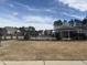 Community pool surrounded by lush landscaping and an iron fence on a sunny day at 185 Bourne Dr, Franklinton, NC 27525