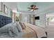 Tranquil bedroom with blue accent wall, ceiling fan, and doorway leading to a sunlit backyard at 185 Twilight Trl, Willow Springs, NC 27592