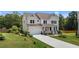 Charming two-story home featuring a manicured lawn, welcoming porch, and attached garage at 185 Twilight Trl, Willow Springs, NC 27592