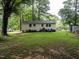Large backyard with lush grass featuring a charming single-story home, a shed, and plenty of open space at 203 Lane Of Sir Kay, Garner, NC 27529