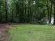 A spacious backyard featuring lush green grass, mature trees, and a wooded area at the property's rear at 203 Lane Of Sir Kay, Garner, NC 27529
