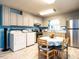 A bright kitchen with stainless steel refrigerator, washer and dryer, and table with a view to the outside at 203 Lane Of Sir Kay, Garner, NC 27529