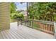 A large outdoor deck features a wood railing, overlooking the backyard with greenery and nearby home at 2218 Watersglen Dr, Apex, NC 27502