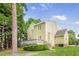 The back of the home has a deck area and green lawn, with mature trees and landscaping at 2218 Watersglen Dr, Apex, NC 27502