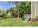 The home has a large, green backyard with mature trees and a deck area at 2218 Watersglen Dr, Apex, NC 27502