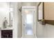 Bright bathroom with a dark wood vanity, granite countertop, decorative mirror, and frosted glass door at 2218 Watersglen Dr, Apex, NC 27502