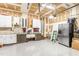 Spacious two car garage featuring white cabinets, work bench, overhead lighting, and stainless steel refrigerator at 2218 Watersglen Dr, Apex, NC 27502