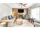 Comfortable living room with a wood accent wall, fireplace, ceiling fan, and an area rug at 2218 Watersglen Dr, Apex, NC 27502