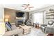 Cozy living room features wood accent wall, fireplace, ceiling fan, and lots of natural light at 2218 Watersglen Dr, Apex, NC 27502