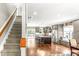 Open-concept design features modern gray cabinets, kitchen island, staircase, and gleaming hardwood floors at 2218 Watersglen Dr, Apex, NC 27502
