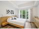 Bright bedroom featuring a window, wood-look floors, and a light wood platform bed with side table at 222 Glenwood Ave # 213, Raleigh, NC 27603