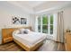 Bright bedroom featuring a window, wood-look floors, and a light wood platform bed with side table at 222 Glenwood Ave # 213, Raleigh, NC 27603