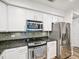 Kitchen featuring stainless steel appliances, white cabinets, and dark stone countertops at 222 Glenwood Ave # 213, Raleigh, NC 27603