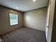 A view of the bedroom with carpet, one window, and neutral colored walls at 2232 Tarboro Road Rd, Youngsville, NC 27596