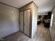 Hallway with a closet leading into an open-concept kitchen with black cabinets and stainless appliances at 2232 Tarboro Road Rd, Youngsville, NC 27596