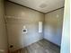 Small laundry room with vinyl flooring, shelving, hookups, and access panel at 2232 Tarboro Road Rd, Youngsville, NC 27596