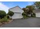 Exterior shot of a two-car garage and an asphalt driveway with lush landscaping at 23 Caldwell, Pittsboro, NC 27312