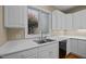 Close-up of the kitchen sink area with white cabinets, counter, and a view outside at 23 Caldwell, Pittsboro, NC 27312