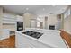 Open-concept kitchen island, cooktop, and view of the living area with a fireplace at 23 Caldwell, Pittsboro, NC 27312