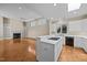 Open-concept living room with a fireplace and parquet wood floors, flowing into the kitchen at 23 Caldwell, Pittsboro, NC 27312