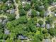Aerial view showcasing a neighborhood with tree-lined streets and traditional homes nestled among mature trees and landscaping at 2400 Fairview Rd, Raleigh, NC 27608