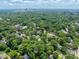 An aerial view of the community nestled among mature trees, with the city skyline in the distance at 2400 Fairview Rd, Raleigh, NC 27608