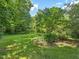 Spacious backyard featuring lush green lawn and mature trees, perfect for outdoor activities at 2400 Fairview Rd, Raleigh, NC 27608