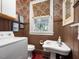 Compact bathroom with floral wallpaper, a pedestal sink, and a washer-dryer combo at 2400 Fairview Rd, Raleigh, NC 27608