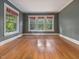 Bedroom with ample natural light from three large windows and hardwood flooring at 2400 Fairview Rd, Raleigh, NC 27608