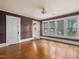 Bedroom features hardwood floors, a door leading to an en-suite, and several windows at 2400 Fairview Rd, Raleigh, NC 27608