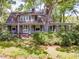 Two-story home with a covered porch, surrounded by mature trees and lush greenery, perfect for outdoor living at 2400 Fairview Rd, Raleigh, NC 27608