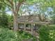 A charming home with a full-length front porch, stone pillars, and ample natural shade from mature trees at 2400 Fairview Rd, Raleigh, NC 27608