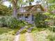 Charming two-story home with a covered front porch and a stone foundation, surrounded by lush landscaping at 2400 Fairview Rd, Raleigh, NC 27608