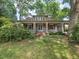 Charming home featuring a welcoming front porch, stone pillars, and lush green landscaping at 2400 Fairview Rd, Raleigh, NC 27608