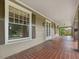 Covered front porch with brick flooring, stone pillars and natural lighting at 2400 Fairview Rd, Raleigh, NC 27608