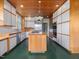 Open kitchen with island cooktop, stainless appliances, and wooden paneled ceiling at 2400 Fairview Rd, Raleigh, NC 27608