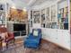Living room featuring built-in bookshelves surrounding a fireplace and a comfortable blue armchair at 2400 Fairview Rd, Raleigh, NC 27608