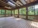 Covered porch with wood flooring, ceiling fans, and views of the surrounding greenery at 2400 Fairview Rd, Raleigh, NC 27608