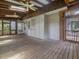 Spacious screened-in porch with wood flooring, ceiling fans, and natural lighting offers an inviting outdoor space at 2400 Fairview Rd, Raleigh, NC 27608