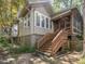 Side exterior view features wooden stairs leading to a screened porch and 'Beware of Dog' sign at 2400 Fairview Rd, Raleigh, NC 27608