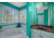 Bathroom featuring a large tub with jets, a vanity, a window and a blue accent wall at 2401 Worthing Ct, Wake Forest, NC 27587