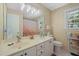 Bright bathroom featuring a double sink vanity, textured wallpaper, and natural light from the window at 2401 Worthing Ct, Wake Forest, NC 27587