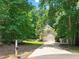 Front view of home featuring garage and driveway surrounded by trees at 2401 Worthing Ct, Wake Forest, NC 27587