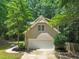 Garage with white doors and driveway surrounded by greenery at 2401 Worthing Ct, Wake Forest, NC 27587