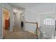Bright hallway featuring a wooden staircase, a chandelier, and white doors at 2401 Worthing Ct, Wake Forest, NC 27587