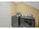 Modern laundry room with updated washer and dryer units and access door at 2401 Worthing Ct, Wake Forest, NC 27587