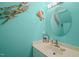 Coastal-themed powder room featuring a unique turtle wall decoration and a round mirror at 2401 Worthing Ct, Wake Forest, NC 27587