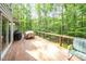 A wooden deck in the backyard surrounded by lush greenery and forest at 2612 Scarlet Sage Ct, Raleigh, NC 27613